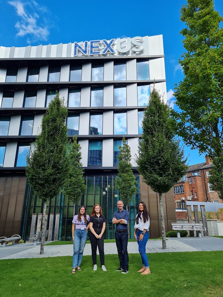 New team members standing outside the Nexus Building Leeds