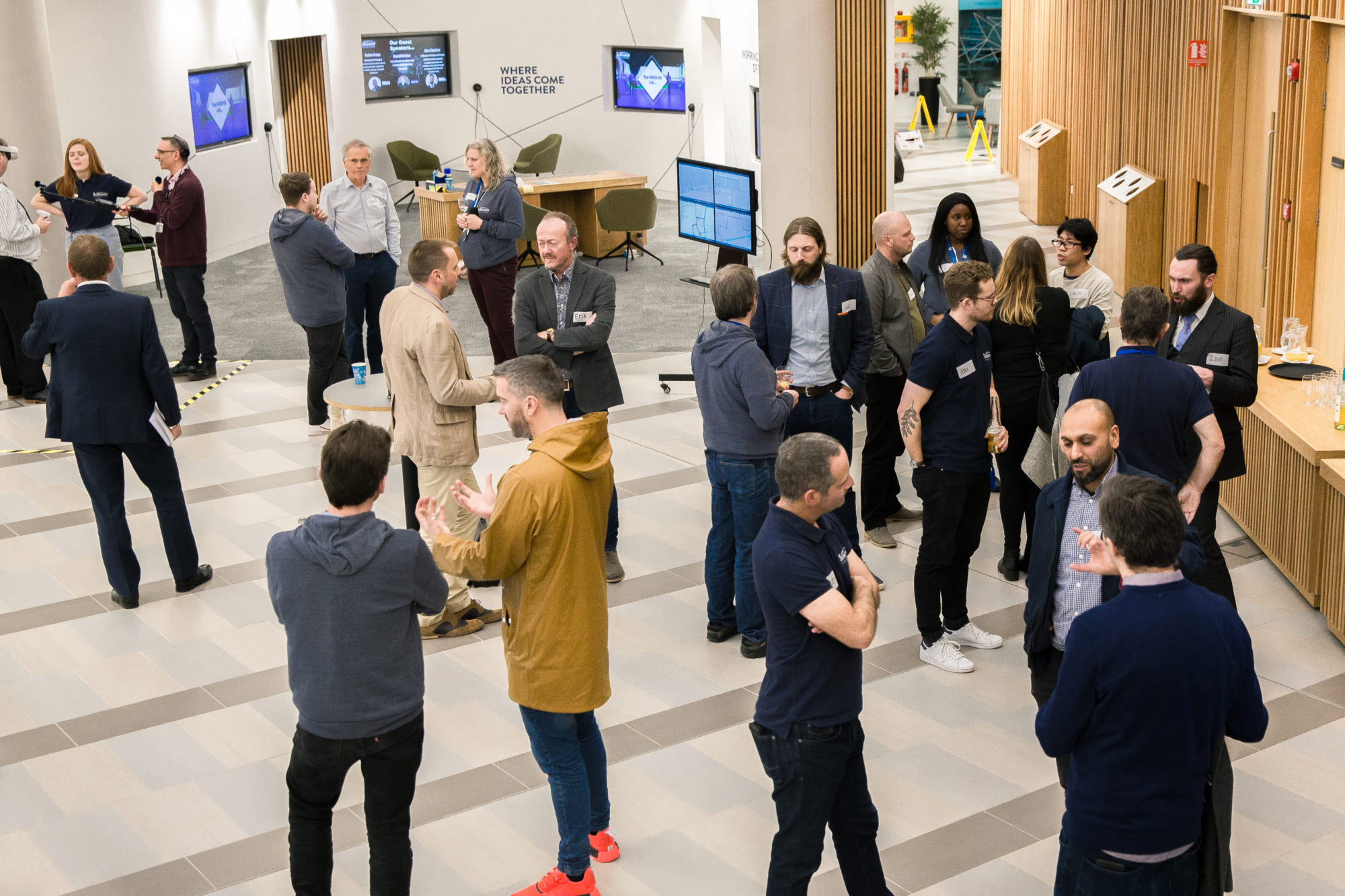 A group of digital twin company members grouped round a screen.