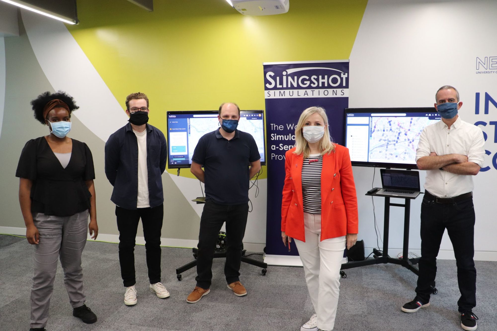 Slingshot Simulations employees stood by a coding screen with the Mayor of Yorkshire